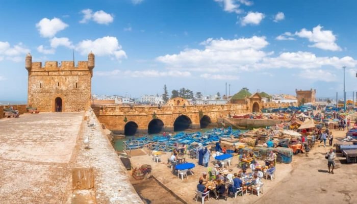 Essaouira, Morocco - April  28, 2019:
People eating street food in old fishing port Essaouira, Morocco